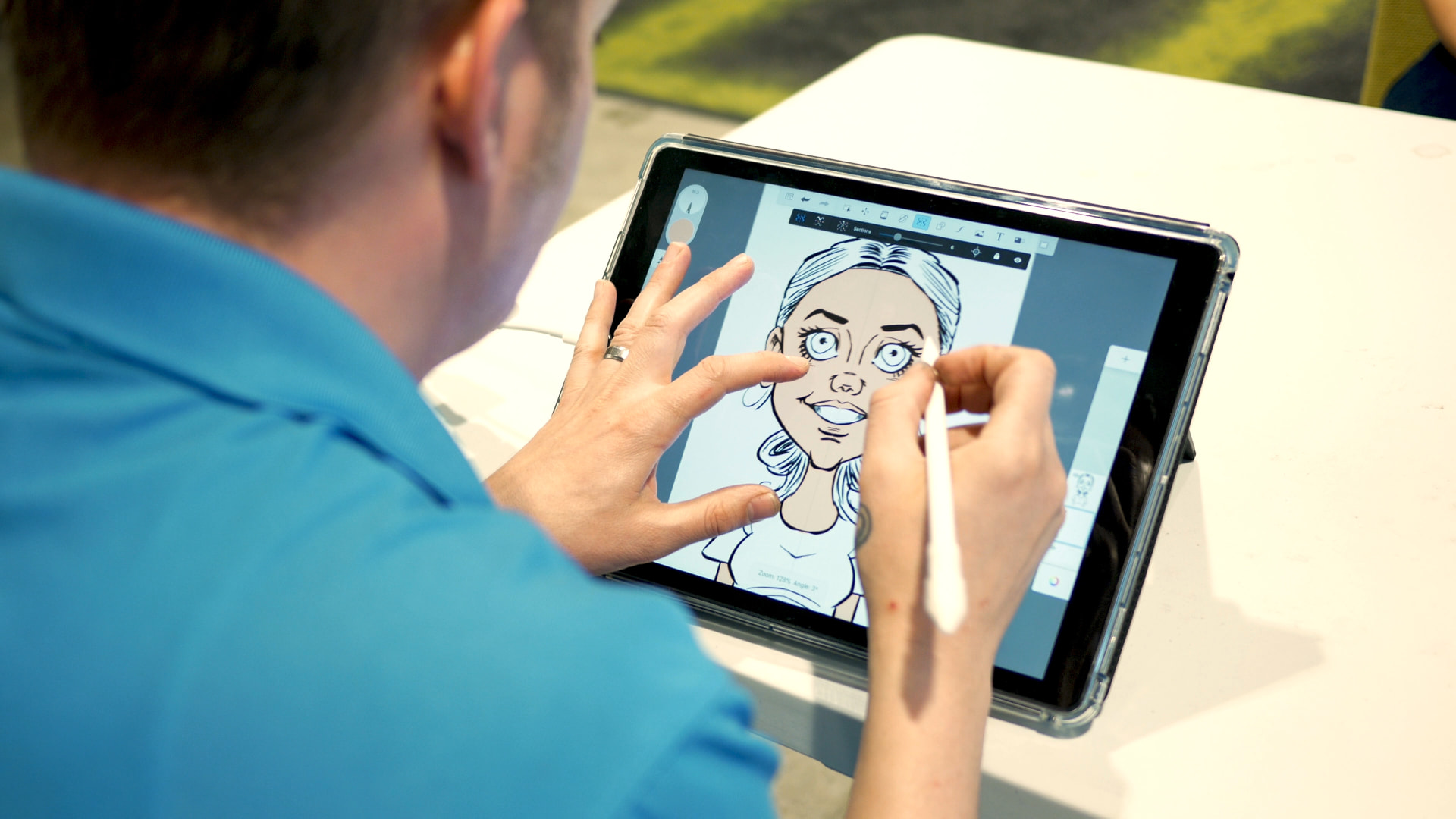 Artist drawing a guest's caricature on a tablet with a white stylus at an event