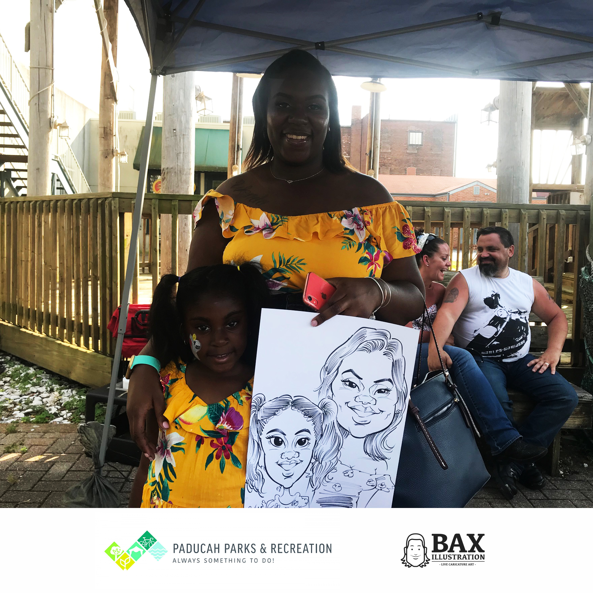 Girls holding caricature by Bax Illustration in Paducah Kentucky at the 2019 Independence Day Celebration