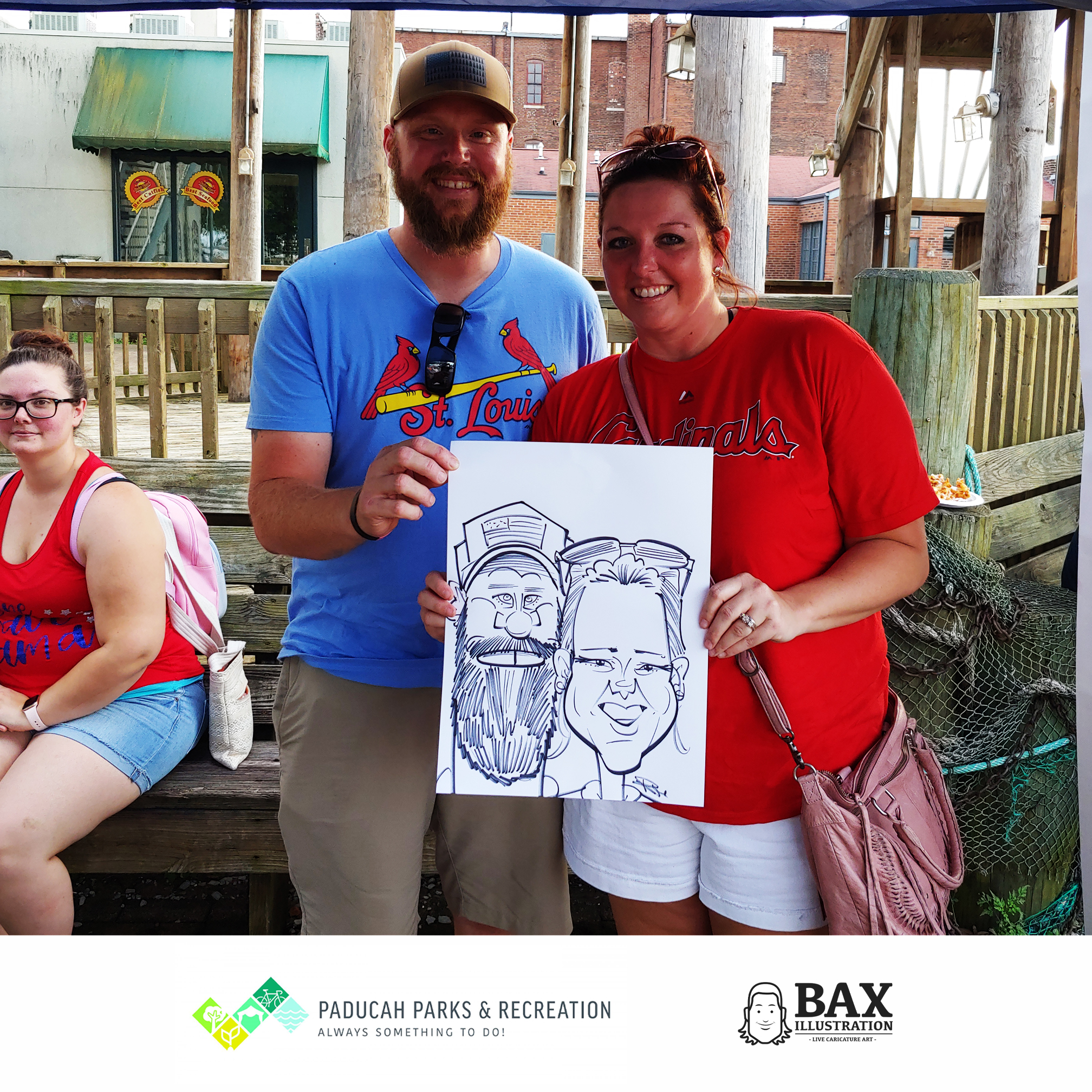 Couple holding caricature by Bax Illustration in Paducah Kentucky at the 2019 Independence Day Celebration