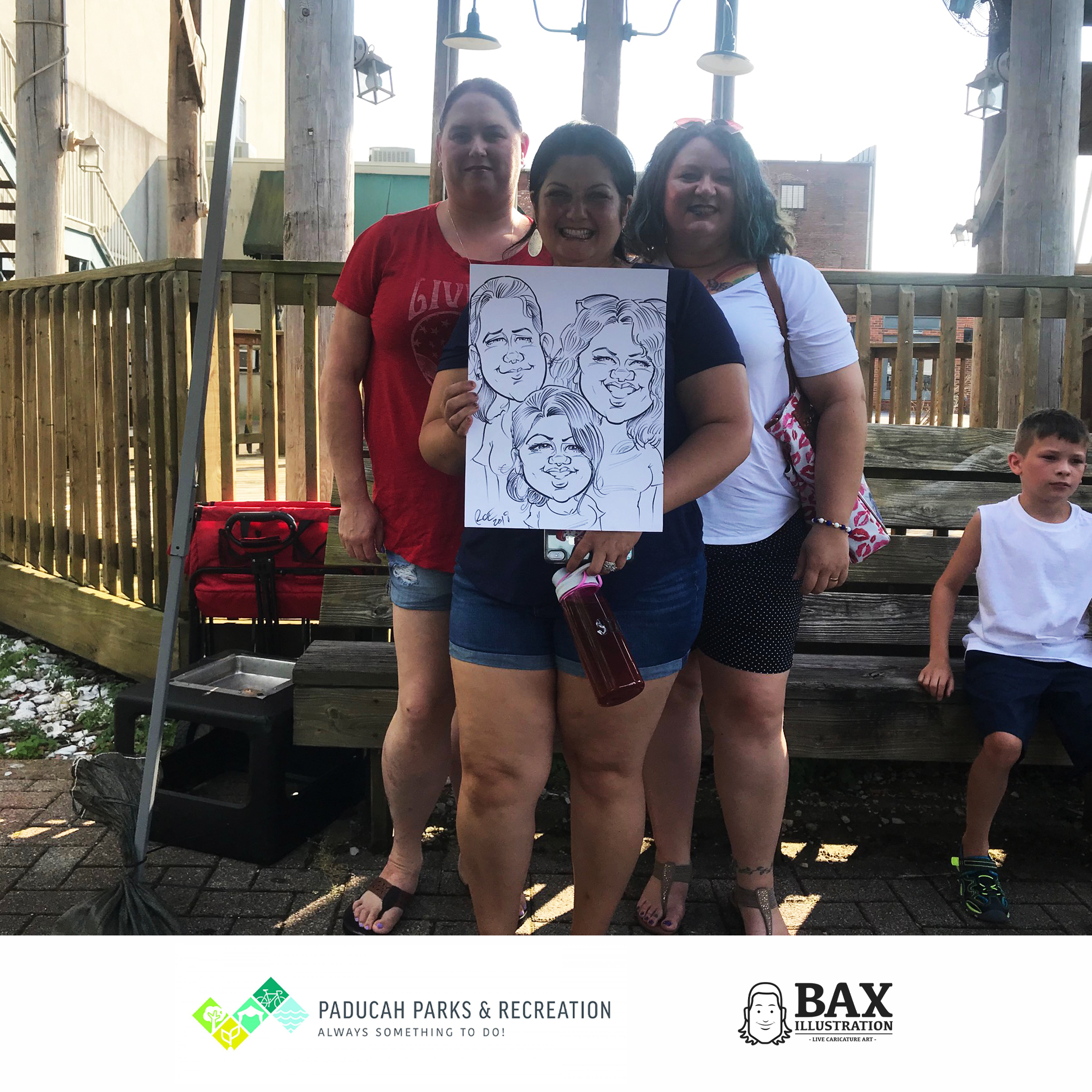 Girls holding caricature by Bax Illustration in Paducah Kentucky at the 2019 Independence Day Celebration